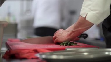 Şef bir restoranda kuşkonmaz kesiyor.