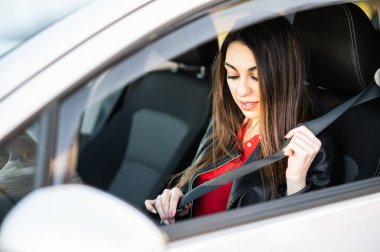 Önce güvenlik. Güzel kadın sürücü araba sürmeden önce emniyet kemerini takıyor..