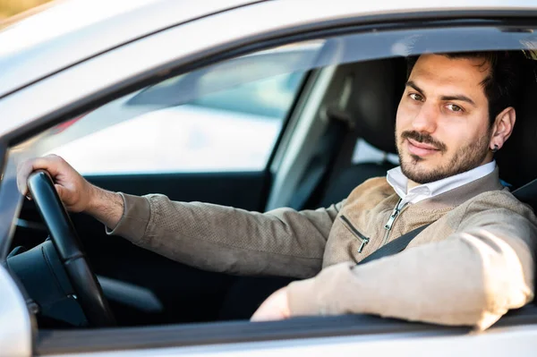 stock image Handsome young man in his car. Smiling while driving a car