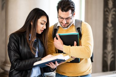 İki öğrenci kapalı bir üniversite salonunda okuyor.