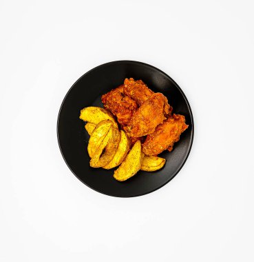 Kore usulü baharatlı kızarmış tavuk ve patates dilimleri. Beyaz arka planda izole edilmiş. Üst manzara, düz uzanma.