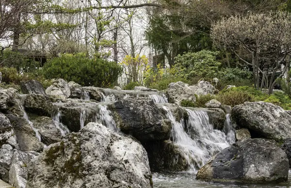 stock image Little waterfall in Setagaya park, Vienna. View of waterfall in beautiful garden at springtime.