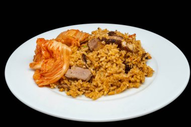 Beyaz tabakta dilimlenmiş kuzu eti ve kimchi ile ev yapımı kızarmış pilav, siyah arka planda izole edilmiş..