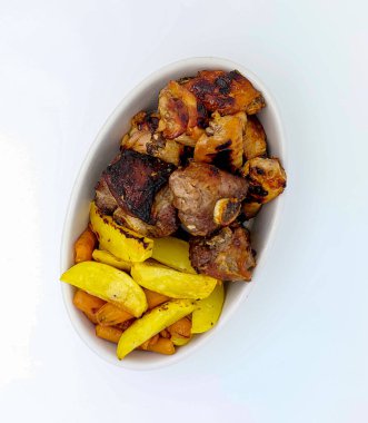 Bir tabak ızgara kaburga ve kızarmış tavuk patates ve ızgara havuçla servis edilir. Üst Manzara. Beyaz arkaplanda izole.