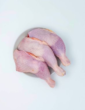 Çiğ tavuk butları beyaz arka planda izole edilmiş ve fotokopi alanı var. Üst manzara, düz uzanma.