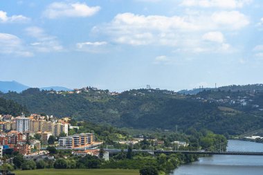 Mondego Nehri, ağaçlar ve binalarla güzel, berrak bir gökyüzü altında Coimbra Şehri manzarası. Peyzaj arkaplanı ve duvar kağıdı.