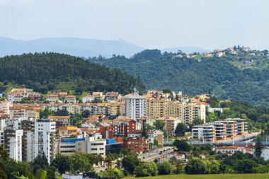 Gökyüzü altında ağaçlar ve binalarla Coimbra şehrinin manzarası. Peyzaj arkaplanı ve duvar kağıdı.