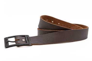 Koyu kahverengi renkli, beyaz arka planda metal tokalı deri kemer takıyordu. Yan görünüm, yakın plan.