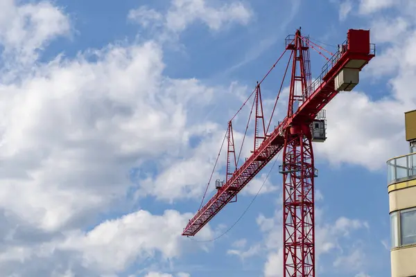 Mavi gökyüzüne karşı kırmızı inşaat kulesi vinci.