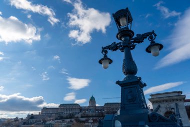 Budapeşte, Macaristan 'da canlı bir mavi gökyüzünün altında arkasında Buda Kalesi olan klasik sokak lambası süslemek.