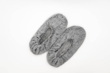Beyaz arka planda izole edilmiş tüylü gri ev terlikleri. Yatak ayakkabısı aksesuar ayakkabı. Üst görünüm veya düz uzanma.