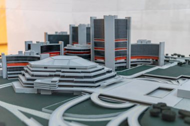 Fütüristik ofis binaları ve kıvrımlı otoyolları olan yol altyapısının yer aldığı modern kentsel kompleksin minyatür mimari modeli ayrıntılı bir ölçekte sergilenmektedir..