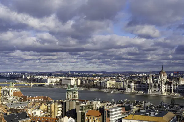 Budapeşte 'nin panoramik manzarası Macar Parlamento Binası ve Tuna Nehri dramatik bir gökyüzü altında.