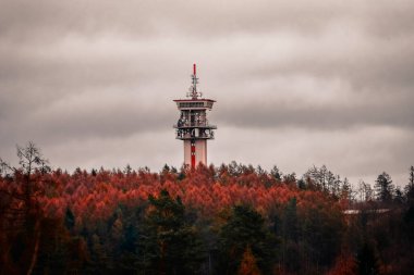 Ormandaki dağın tepesindeki kulenin dikey görüntüsü.