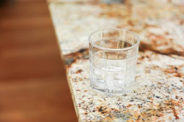 Mutfak masasında bir bardak temiz su.