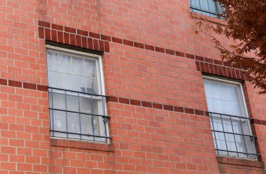 İki penceresi ve panjuru olan eski kırmızı tuğla duvar