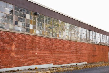 tuğla duvarları ve pencereleri olan terk edilmiş bir bina.