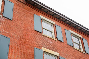 Riga şehrindeki evin duvarında eski ahşap pencereler.