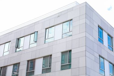 Pencereleri ve balkonları olan modern bir bina. Modern ofis binası. Yeni dairenin mimarisi.