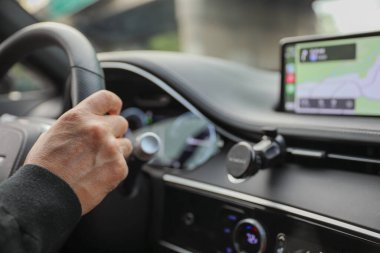 Gösterge paneliyle araba süren bir adam.