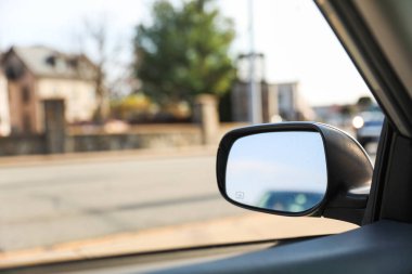 Araba aynanın içinde gidiyor, arka taraftan görünüyor.