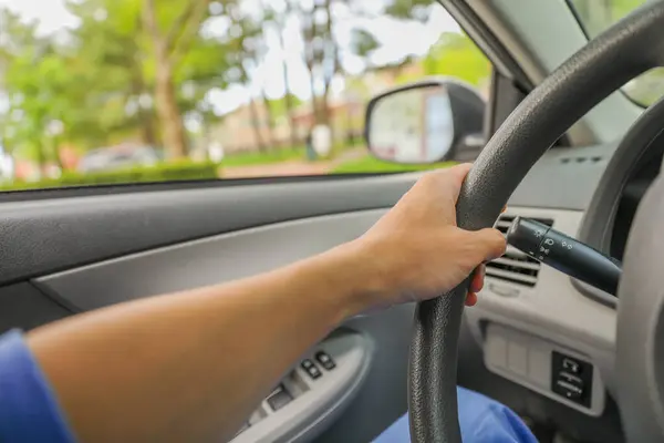 Direksiyon başında araba süren bir kadın eli