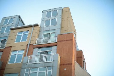 Pencereleri ve balkonları olan modern bir binanın ön cephesi