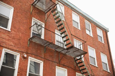 Arka planda pencereleri ve tuğla merdivenleri olan eski bir ev..