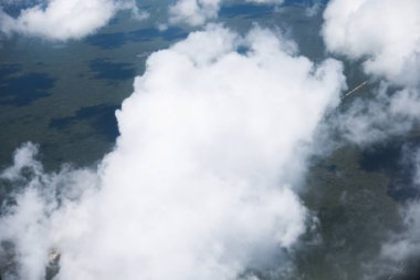 Yazın bulutların arasında uçan uçağın hava görüntüsü.