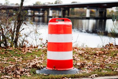 Kırmızı trafik konisi yol kenarında.
