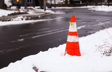 Sokakta kırmızı çizgili trafik konisi