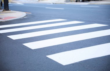 Yoldaki beyaz yaya geçidinde. Yaya geçidinin caddesi.