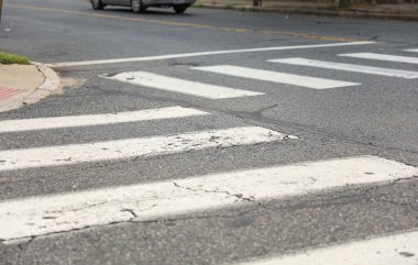 Beyaz boyalı asfalt yol tabelası ve yaya geçidi