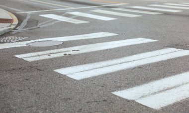 Asfalt sokakta beyaz yaya geçidi tabelası