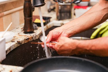 Metal bir boru kullanarak fayansı fırçayla kesen bir işçinin görüntüsünü kapatın.