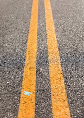 Sarı ve turuncu çizgileri olan asfalt yol