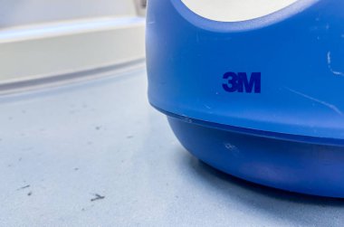 Mavi saplı mavi ve beyaz plastik bir kap..