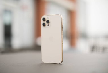 Masanın üzerinde bulanık arkaplanı olan beyaz cep telefonu