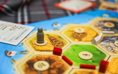 Satranç tahtasıyla ahşap bir zar tutan bir adamın ellerini kapatın..