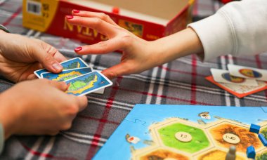 Yakın plan. Arkadaşlarıyla kağıt oynayan bir kadın.