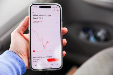 Akıllı telefon ekranında kırmızı arabası olan akıllı telefon kullanan bir adam.