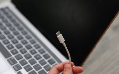 Güç kablosu tutan bir adam.