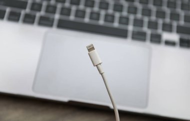 Masanın üzerinde beyaz kablo olan USB şarj aleti.
