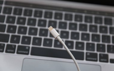 Bir dizüstü bilgisayarın klavyesini ve beyaz kabloyu kapat.