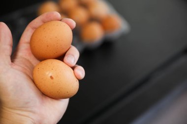 Mutfakta yumurta tutan bir kadın.