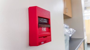 Hastanenin kapısındaki çalar saat. Alarm düğmesi kırmızı düğmedir..