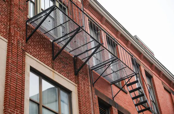Tuğla bir binanın üzerindeki metal balkonlar.
