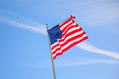 Mavi gökyüzünde dalgalanan Amerikan bayrakları