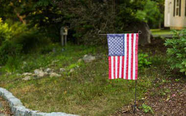 Bahçedeki çitin üzerinde Amerikan bayrağı