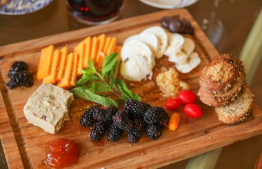 Arka planda çeşitli peynir çeşitleri olan peynir tahtası